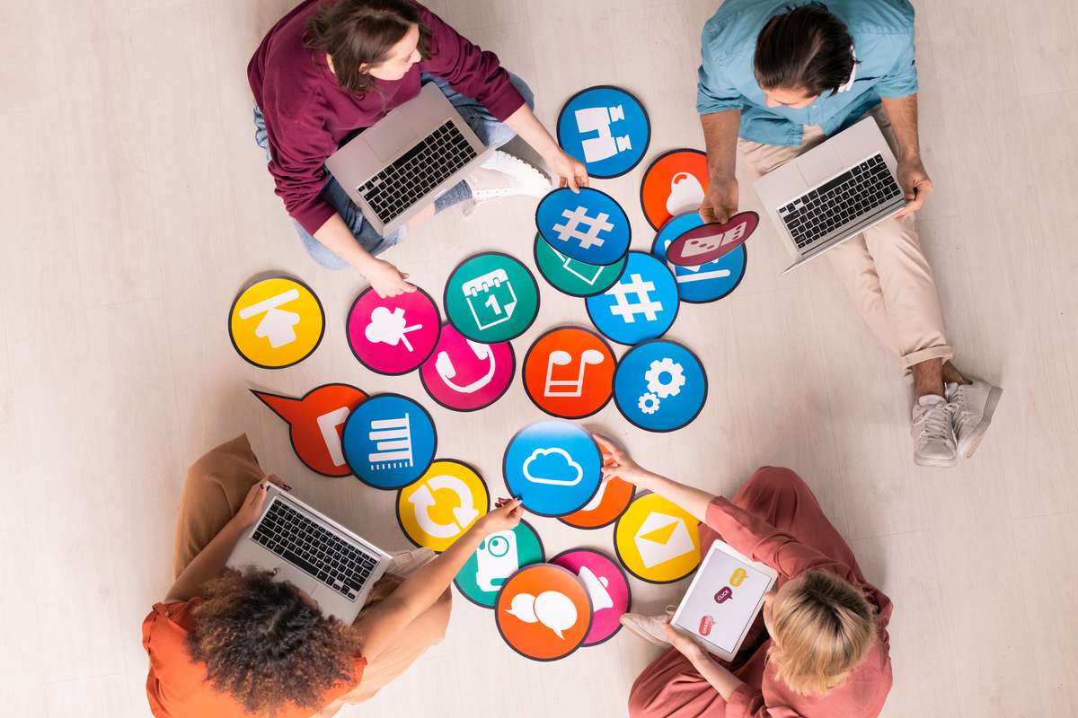Des participants concentrés autour d’un ordinateur portable, en train de travailler sur un calendrier de publications ou de rédiger un post ensemble. L’image montre un environnement de formation dynamique et collaboratif.